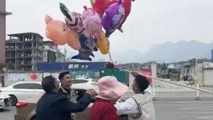 3月22日,湖北恩施,气球不慎飞走挂在树上,几名年轻小伙接力帮老人取下