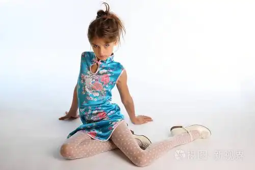 穿着亚洲蓝色连衣裙的漂亮女孩正坐在白色的背景上.