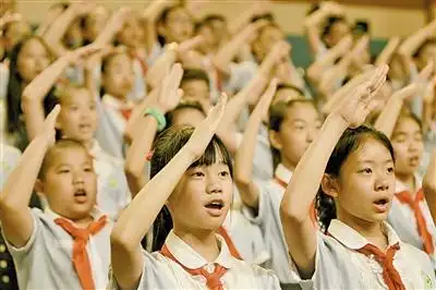 活动现场,孩子们向国旗致敬并高唱国歌.陈翔摄