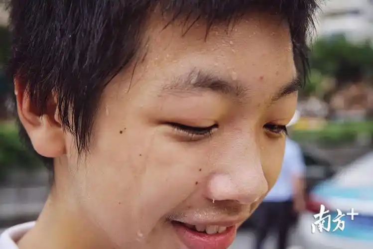 高考遇到高温,一名在华师附中考场外候考的考生满头大汗.