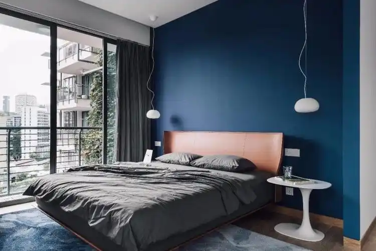 深蓝色的卧室可以安抚身心的疲惫,搭配灰色成套的素雅床品,优雅而