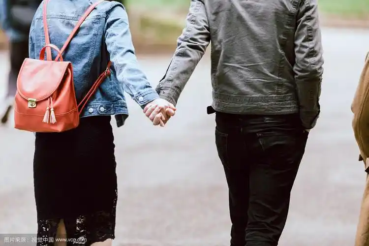 一对手牵手走在后面的情侣
