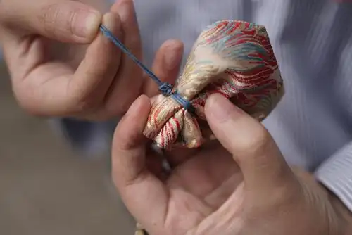 4.用平结卡紧绑香囊的束口绳