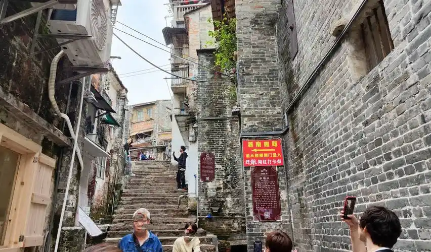 三十三级台阶街口的墙边,正是剧中高启强和高启盛兄弟,身穿强盛小灵通