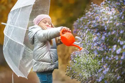 小女孩在花园里浇花在秋天