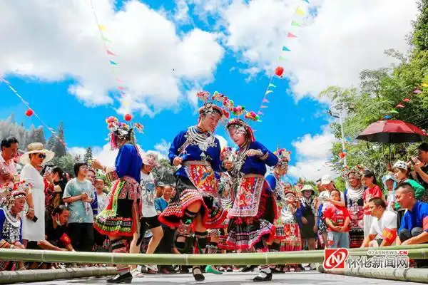 图说怀化侗族阿妹与游客一起在跳竹竿舞