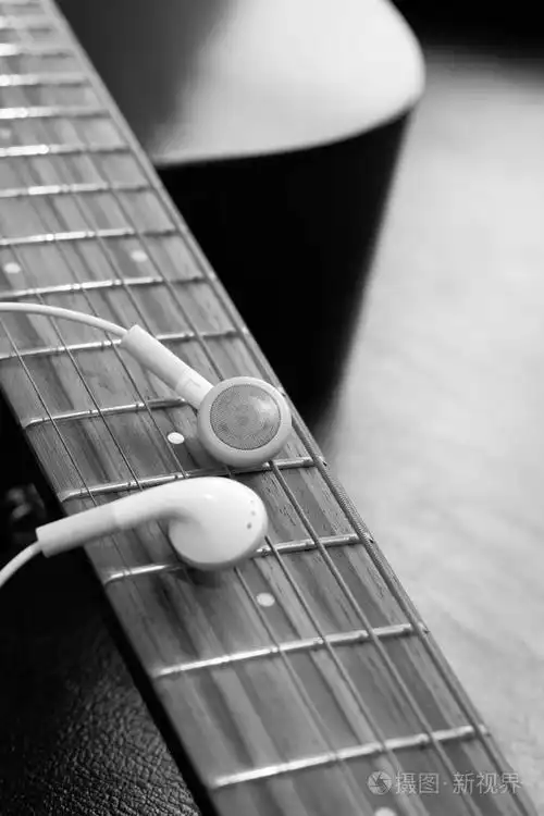 原声吉他指板上的白色耳机