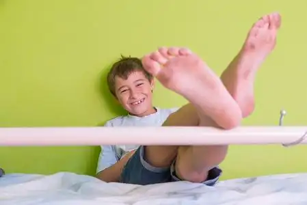 小孩笑着脏脚,坐在床上照片