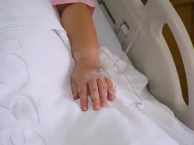 在医院的一个女人的手关闭盐水解决方案照片