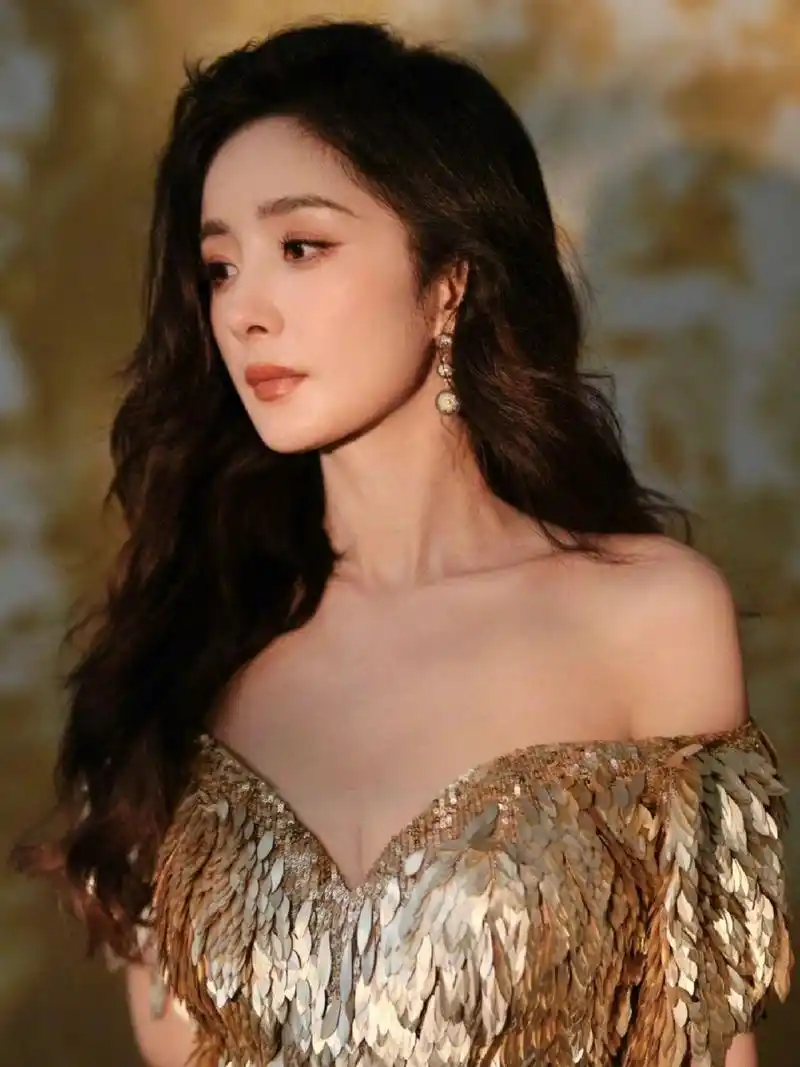 杨幂拍新造型好有女人味,妆容精致留着长卷发,穿着一袭金色亮片礼服裙