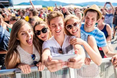 人群背景中一起快来自拍的年轻人们