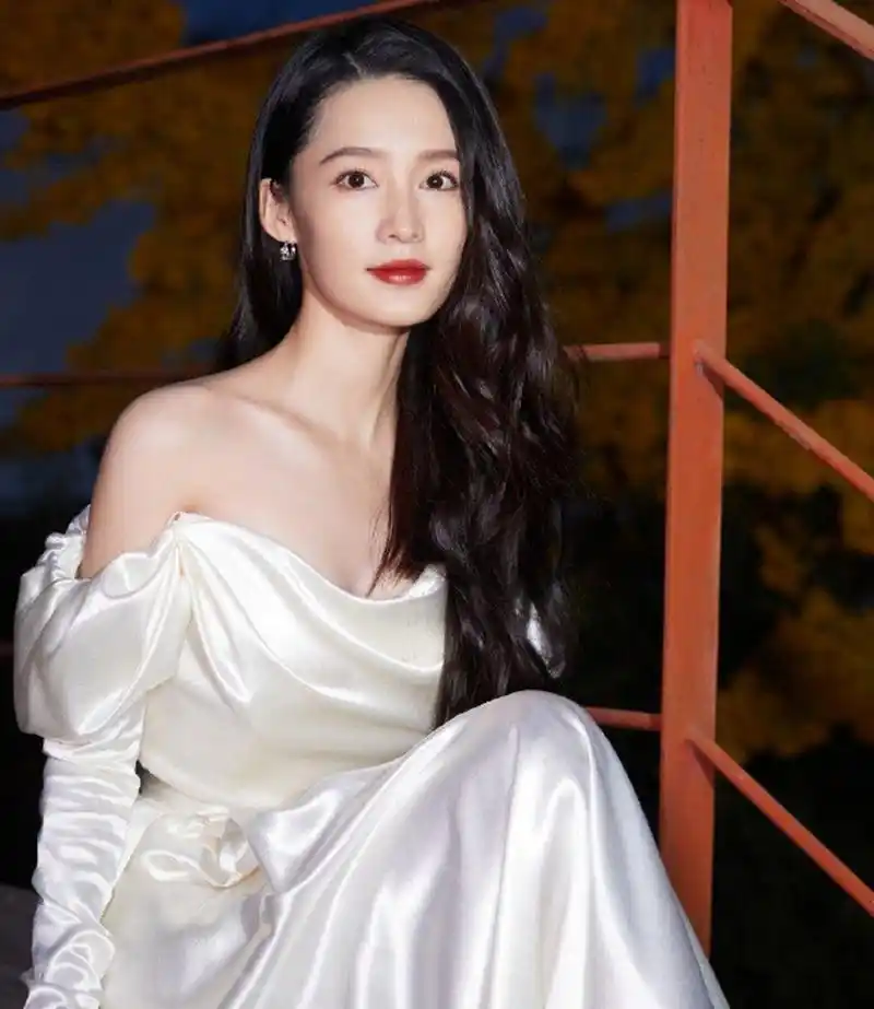 李沁一袭白色抹胸裙,肤白貌美气质佳.