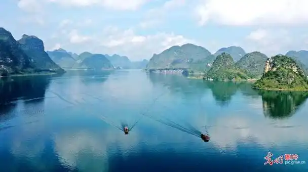 2023年10月1日,广西靖西市渠洋湖风轻云淡,水天一色,游客乘船徜徉在