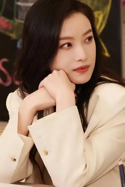 倪妮拍摄大片,身着白色衬衫与中长款西装外套,搭配白色短裤和高跟凉鞋