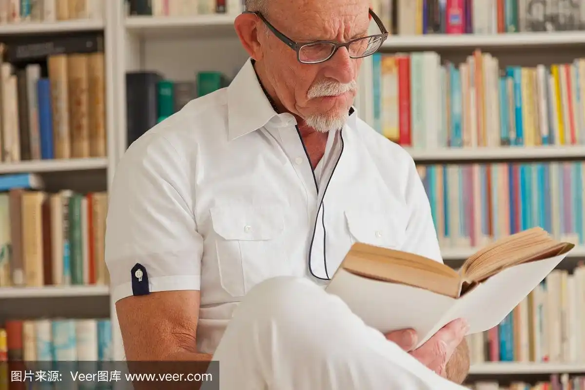 戴眼镜的老人在书柜前看书.