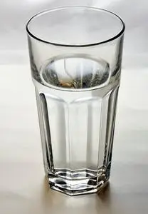 冰结构纯矿泉水加冰块和柠檬有水滴的冰玻璃冰水蓝色背景下的干净水柱