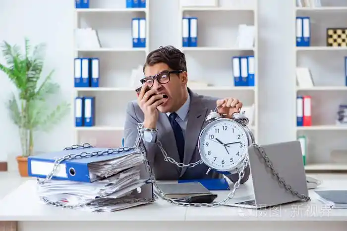 忙碌的雇员被锁在办公桌前