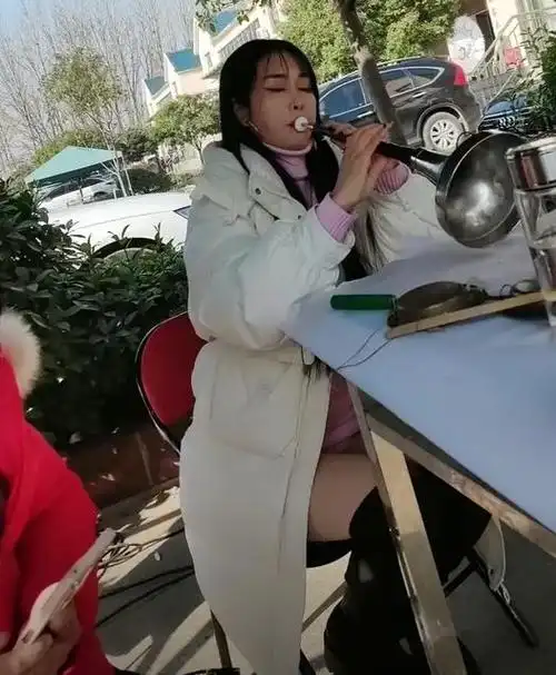 山东女子吹喇叭神情陶醉长相漂亮打扮靓丽引人注意