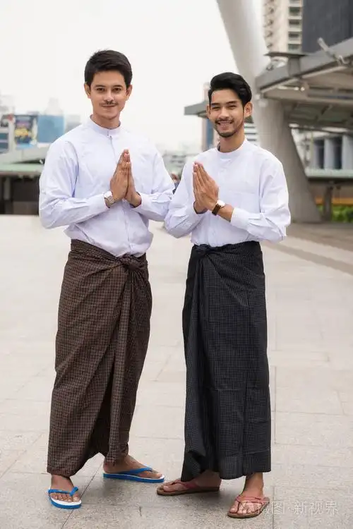 英俊的缅甸人或缅甸男子的肖像龙奕机械传统的礼服执行敬礼或您好手势