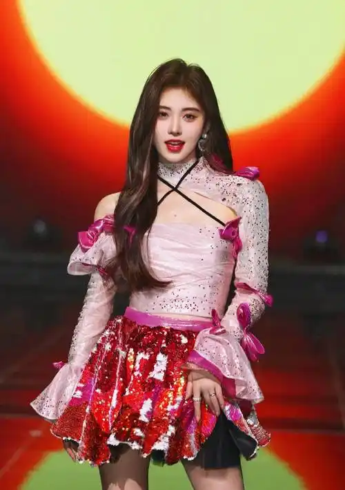 图中,鞠婧祎身穿白色露肩上衣,搭配红色闪亮的小短裙,她俏脸靓丽,浓眉