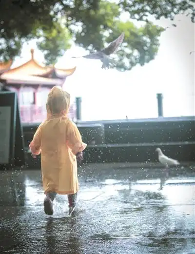 西湖边,孩子在雨中玩耍.记者 夏阳 摄