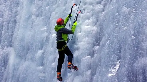 person climbing up a snowy mountain