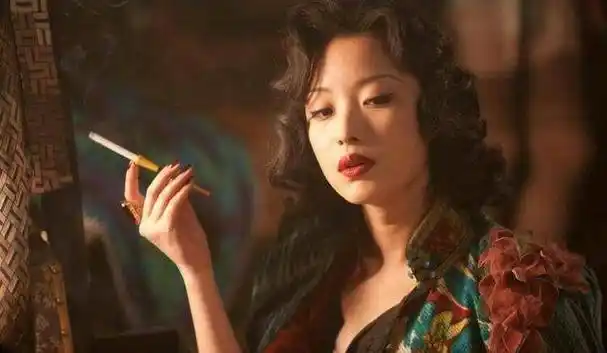 她穿上旗袍,走起路来那叫一个婀娜多姿,抽烟的样子也特有范儿.