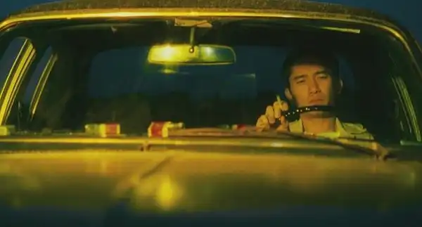 shot_43:在黄色的暖光下,黎耀辉一个人驾驶着车,前往伊瓦苏,看瀑布.