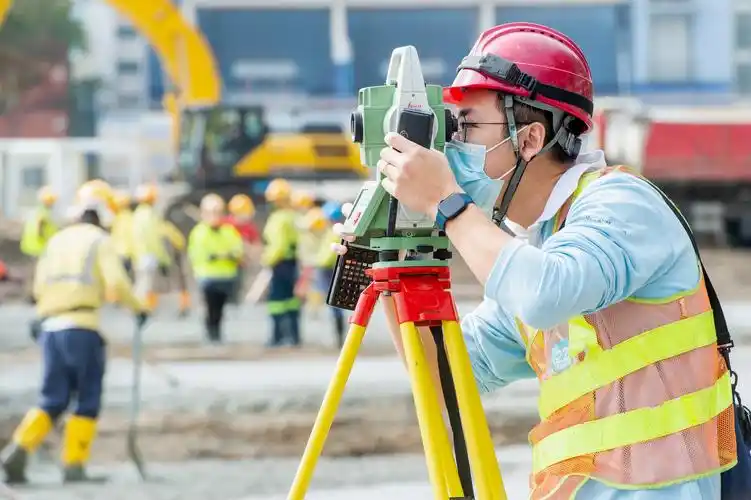 2月24日,香港青衣方舱医院建设工地,工人在进行测量.