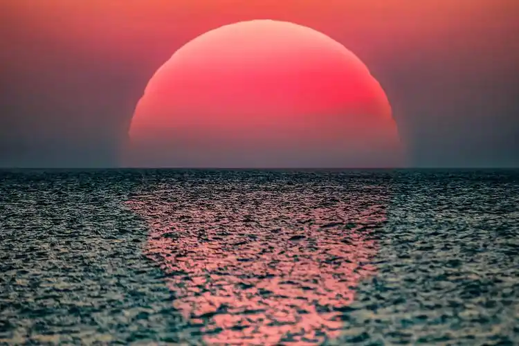 田园诗般的日出,巨大的太阳从海上升起.图片下载