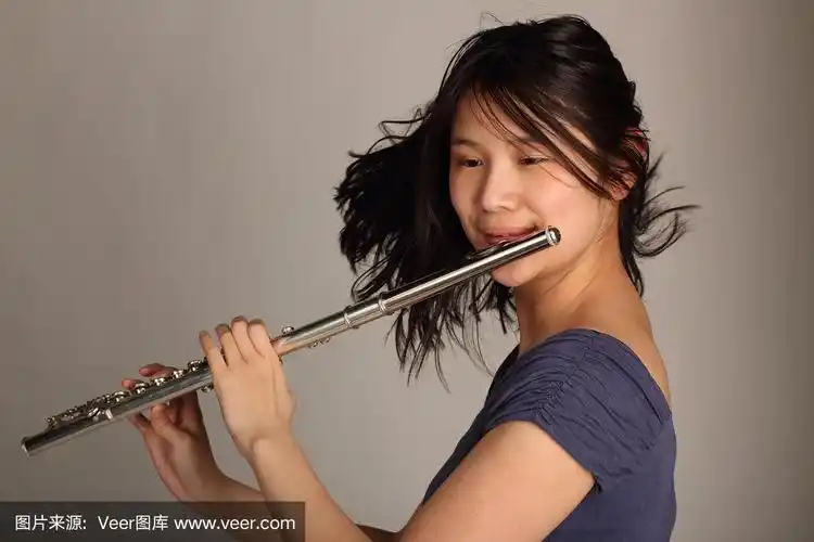 美丽的亚洲女人吹长笛