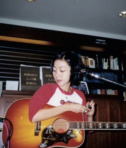 陈绮贞晒早年演出照 留利落短发抱吉他唱歌青涩专注