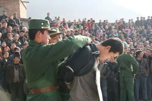 请问,在审判大会上,男犯人五花大绑,还戴者背铐,女犯为什只戴手铐,是