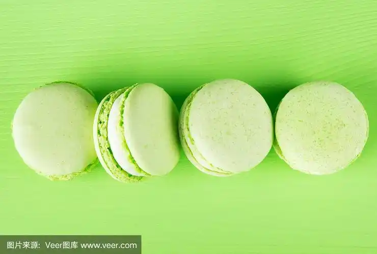 长长的一排浅绿色的马卡龙,在绿色的背景上
