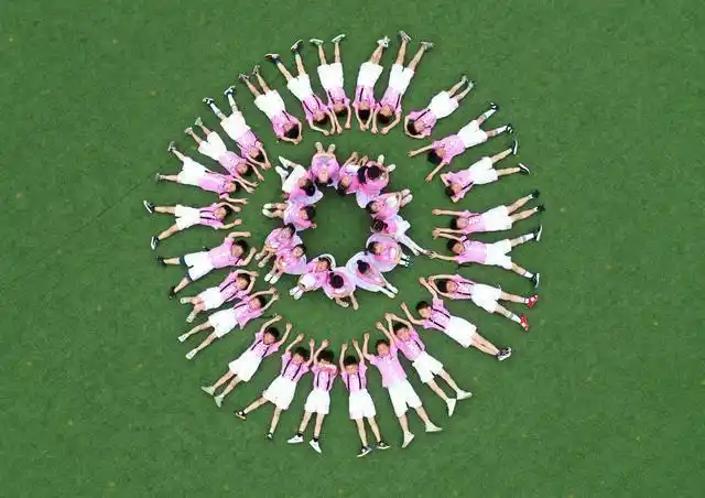 县实验小学附属幼儿园的小朋友在操场上摆出不同的姿势,拍摄毕业照