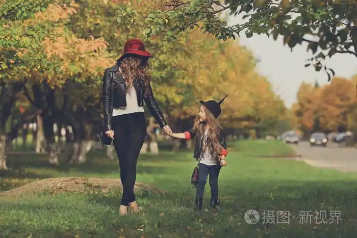 母亲和女儿在公园散步手牵着手