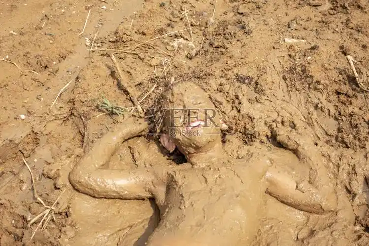 小男孩在泥里玩图片素材