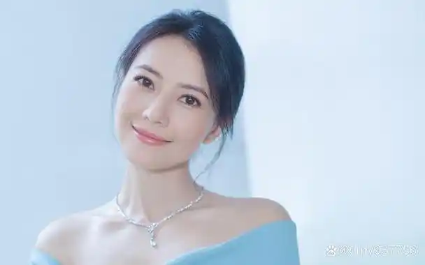 照片中,高圆圆穿着一件黑色的斜肩吊带裙,露出了白皙的美肩和纤细的