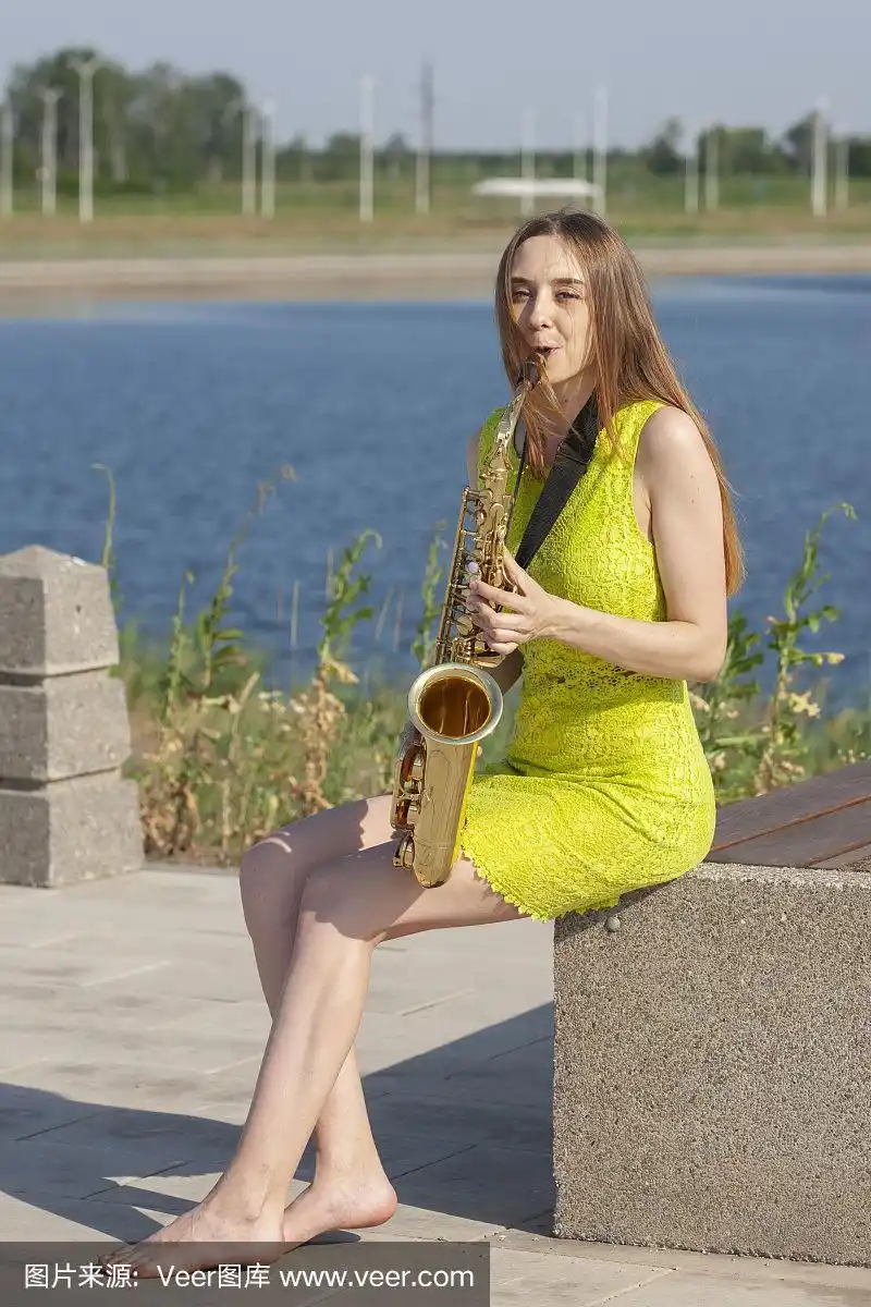 年轻美丽的萨克斯管手-户外的大自然.