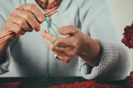 手工制作的针线活.老妇人为孙子们织一条羊毛线围巾.爱好和退休金照片