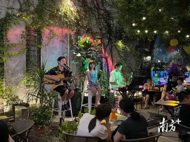 在星湖酒吧风情街的一家餐吧内,三名驻唱歌手正在演出.卢逸轩 摄