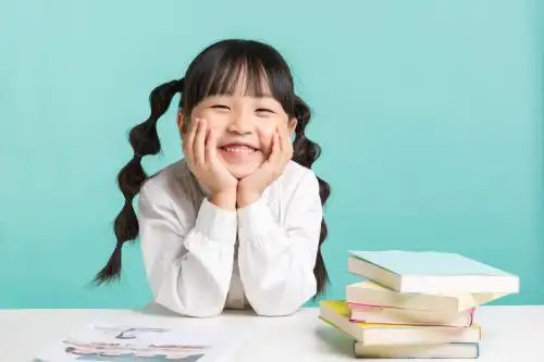 可爱的小学女生双手托着脸开心笑着