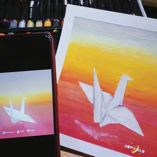 先用美纹纸胶带将油画棒四边固定,在另一张纸画出千纸鹤外形用美工刀