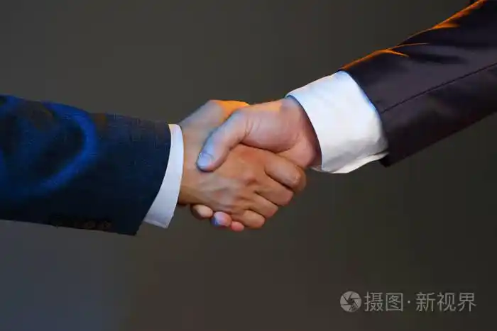 穿着西装的男人握手作为你好在办公室特写