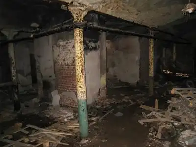 的黑暗地下室的窗户,用生锈的钢格子在旧的令人毛骨悚然的废弃豪宅里