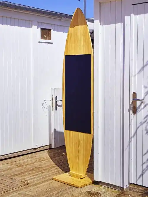 海滩白色展位上的黑板形状的冲浪板