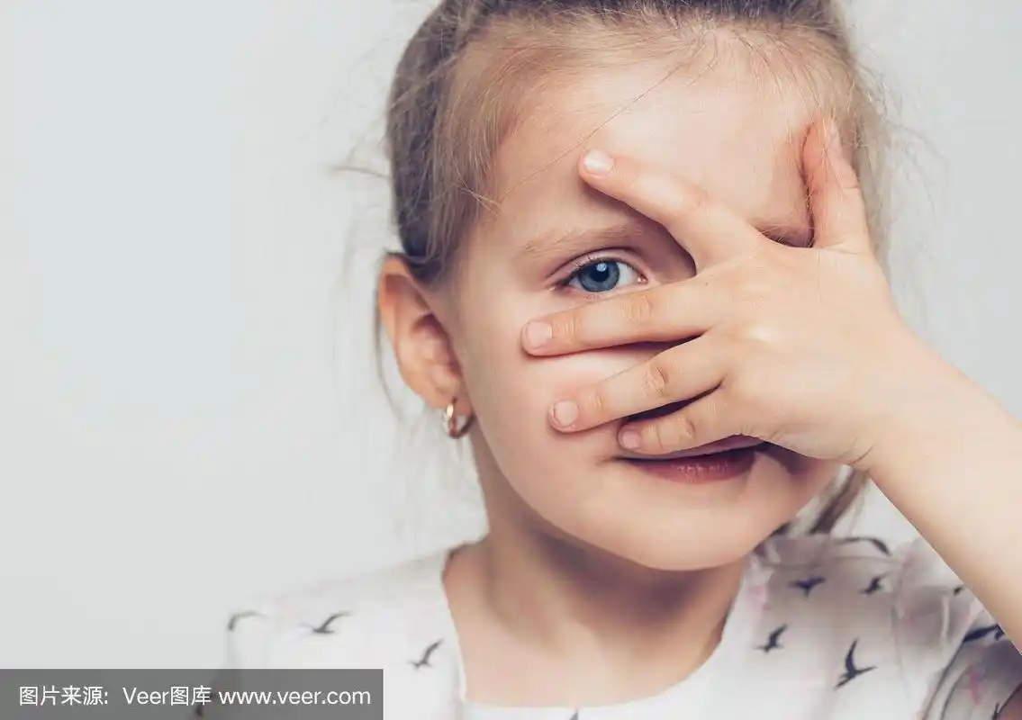 可爱的小女孩用手捂着脸微笑