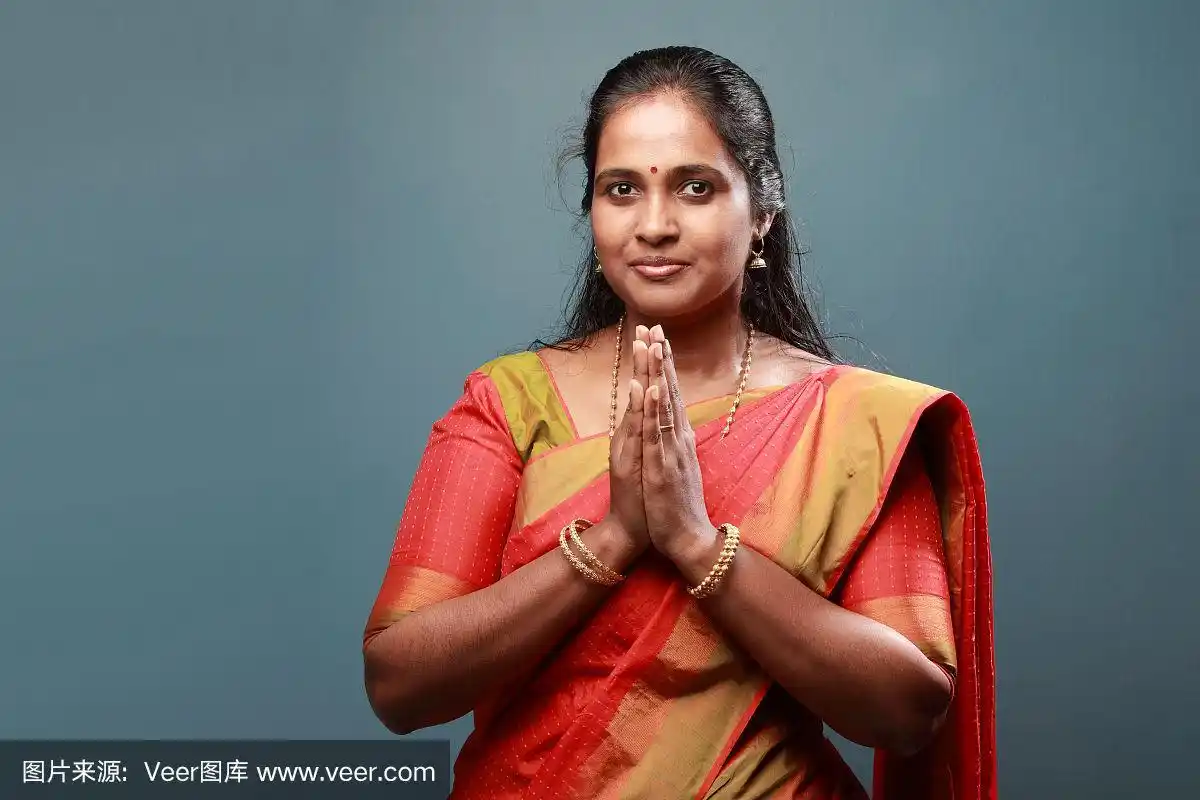 穿着传统服装的南印度妇女双手合十敬礼