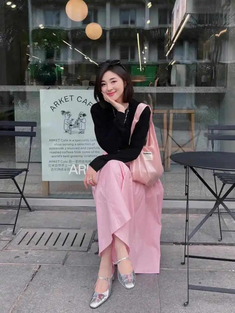 黑色的上衣搭配上粉色的伞状鲤鱼裙子又显瘦,轻松穿出时髦感,漂亮大方