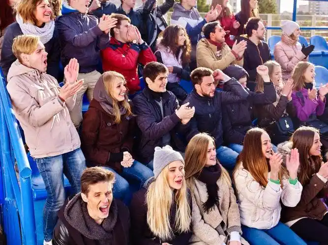 坐在沙发上看足球的激动的人